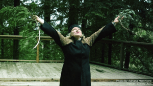 woman reaching up with branches in hands