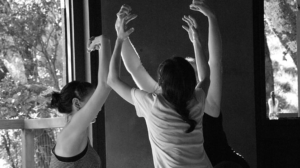 3 women squatting with arms reaching towards sky