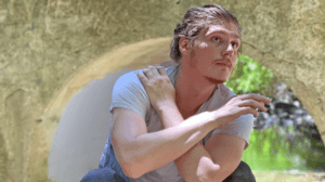 young man looking up crouching and crossing arms