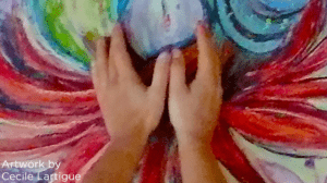 woman holding hands cupping part of her drawing that looks like wings emerging from sides of hands